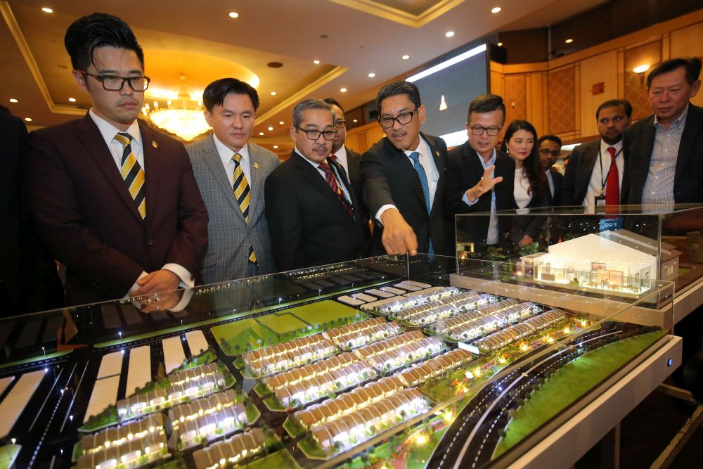 Perak Mentri Besar Ahmad Faizal Azumu (fourth from left) looks at a replica of a housing project to be built on 10ha site in Tronoh August 9, 2018. u00e2u20acu201d Picture by Miera Zulyana