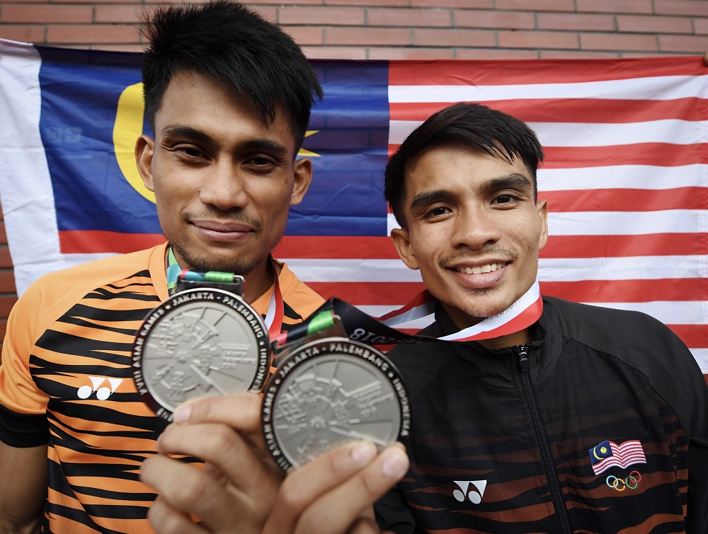 Silat athletes Mohd Al Jufferi Jamari (left) and Muhammad Faizul M Nasir (right) pose with their silver medals in Jakarta August 27, 2018. u00e2u20acu201d Bernama pic