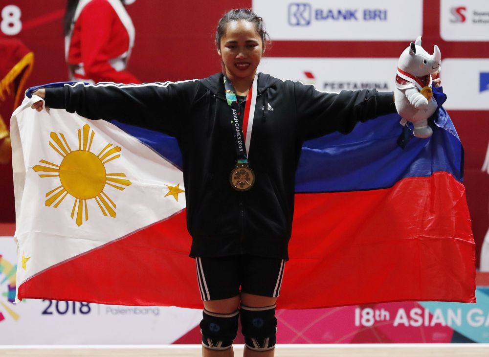 Gold medalist Hidilyn Diaz of the Philippines poses with her national flag August 21, 2018. u00e2u20acu201dReuters pic