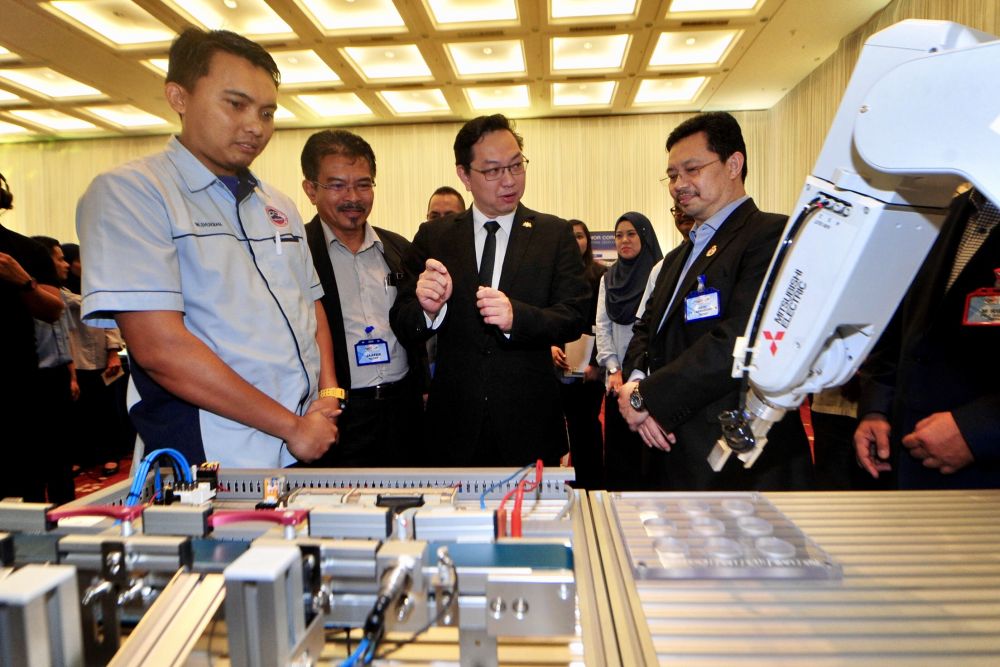 Puah (centre) and Johor Corporation president and chief executive Datuk Kamruzzaman Abu Kassim (right) are pictured at the Persada Johor International Convention Centre August 1, 2018. u00e2u20acu201d Picture by Ben Tan