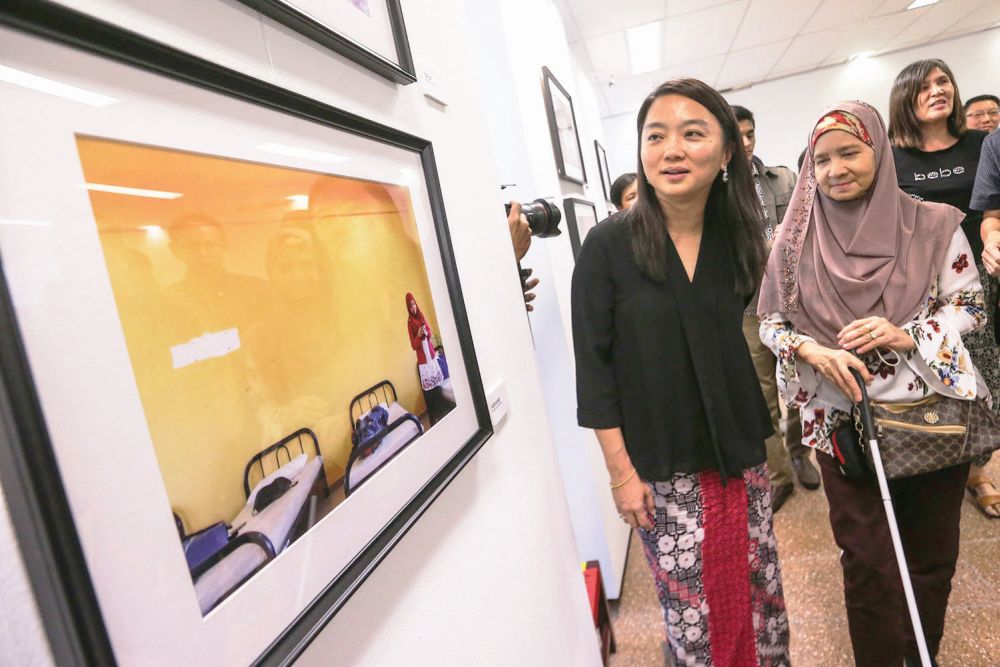 Hannah Yeoh (left) checks out the artworks by Jamaliah (right) at the exhibition. u00e2u20acu201d Picture by Hari Anggara