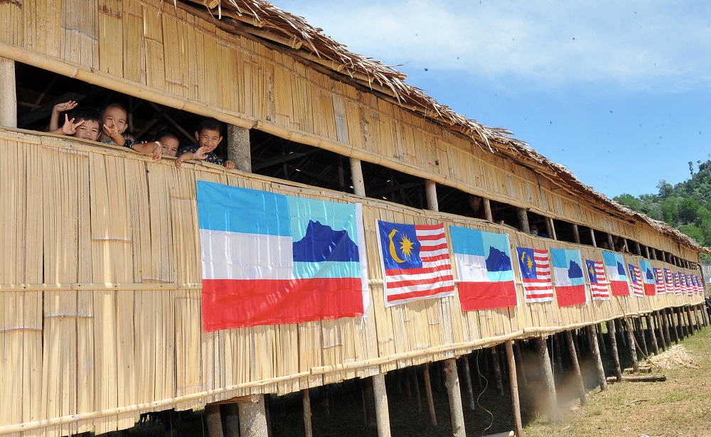 Murut people are seen in a longhouse adorned with Malaysia and Sabah flags in Nabawan, Sabah. — Bernama pic 