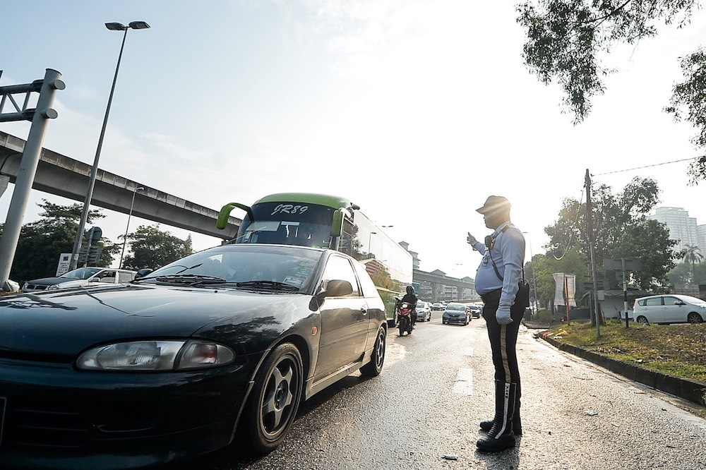 Subang Jaya traffic police, Sergeant Asliyas Sulaiman, controls traffic flow in front of the Sri Maha Mariamman Devasthanam temple, November 28, 2018. u00e2u20acu201d Picture by Hari Anggara
