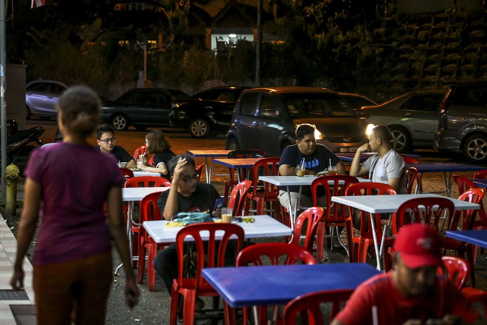 Customers sitting on tables set by the roadside at a Mamak restaurant in Bandar Sri Damansara, November 20, 2018. u00e2u20acu201d Picture by Hari Anggara