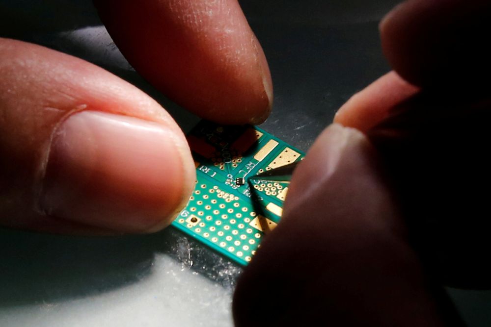 A researcher plants a semiconductor on an interface board during a research work to design and develop a semiconductor product at Tsinghua Unigroup research centre in Beijing, China, February 29, 2016. u00e2u20acu201d Reuters pic