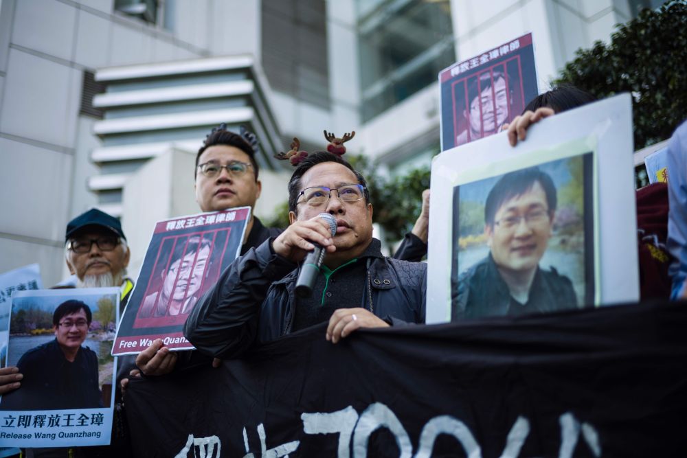 Veteran pro-democracy lawmaker Albert Ho (centre) speaks as fellow activists hold placards of detained Chinese human rights lawyer Wang Quanzhang at a rally outside the Chinese Liaison Office in Hong Kong December 26, 2018. u00e2u20acu201d AFP pic