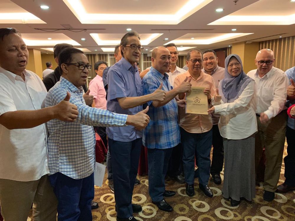 Hajiji (centre) and Masidi (third from left), along with other ex-Sabah Umno elected representatives, pose for a picture. u00e2u20acu201d Picture via social media