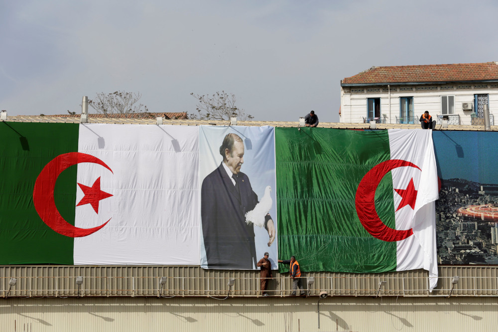 Algerian city employees install Algerian flags and Presidentu00e2u20acu2122s Abdelaziz Bouteflika poster on the streets ahead of the Parliamentary election in Algiers, Algeria April 26, 2017. u00e2u20acu201d Reuters pic