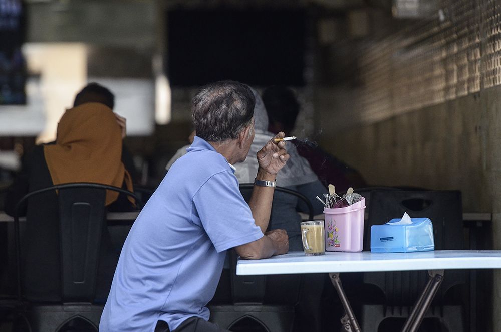 A man smokes outside an eatery in Petaling Jaya January 1, 2019. u00e2u20acu2022 Picture by Miera Zulyana