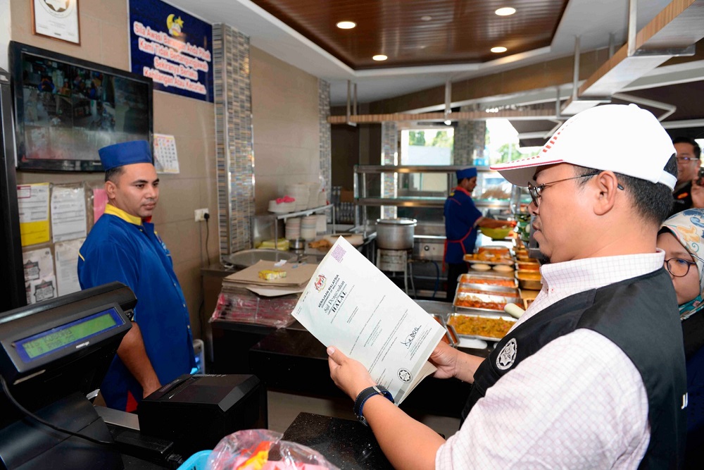 A Jakim officer checks the halal certificate of a restaurant in Alor Setar January 15, 2019. u00e2u20acu201d Bernama pic