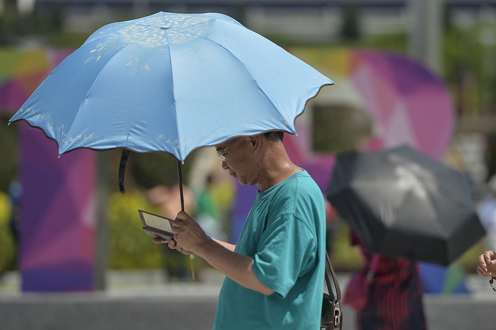 A tourists carries an umbrella on a hot day in Putrajaya February 26, 2019. u00e2u20acu2022 Picture by Miera Zulyana