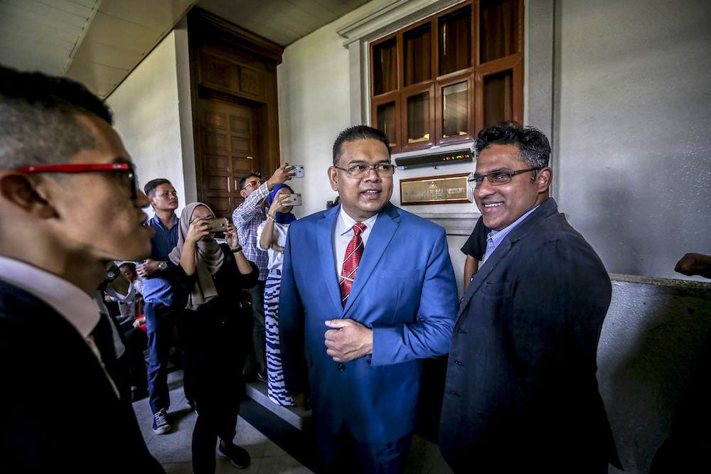 Datuk Lokman Noor Adam and Datuk Mutalif Abdul Rahim (right) wait outside a courtroom at the Kuala Lumpur Court Complex March 28, 2019. u00e2u20acu201d Picture by Firdaus Latif