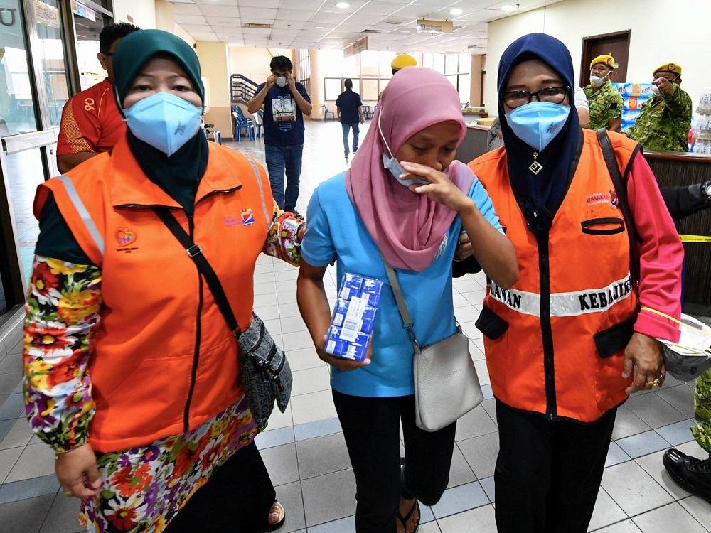 A woman is assisted into the Pasir Gudang Municipal Council Stadium medic base for treatment March 16, 2019. — Bernama pic