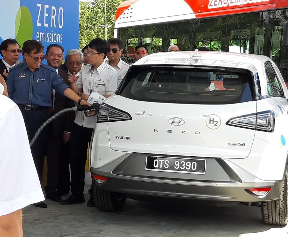 Chief Minister Datuk Patinggi Abang Johari Openg (left) refueling a specially-designed car with hydrogen after the launch of the integrated hydrogen production plant and refuelling station, May 27, 2019. u00e2u20acu201d Picture by Sulok Tawie