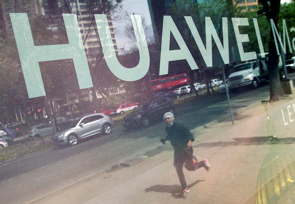 A man is reflected in a glass advertising with the Huawei's company logo at a bus stop in Mexico City, Mexico February 22, 2019. u00e2u20acu201d Reuters pic