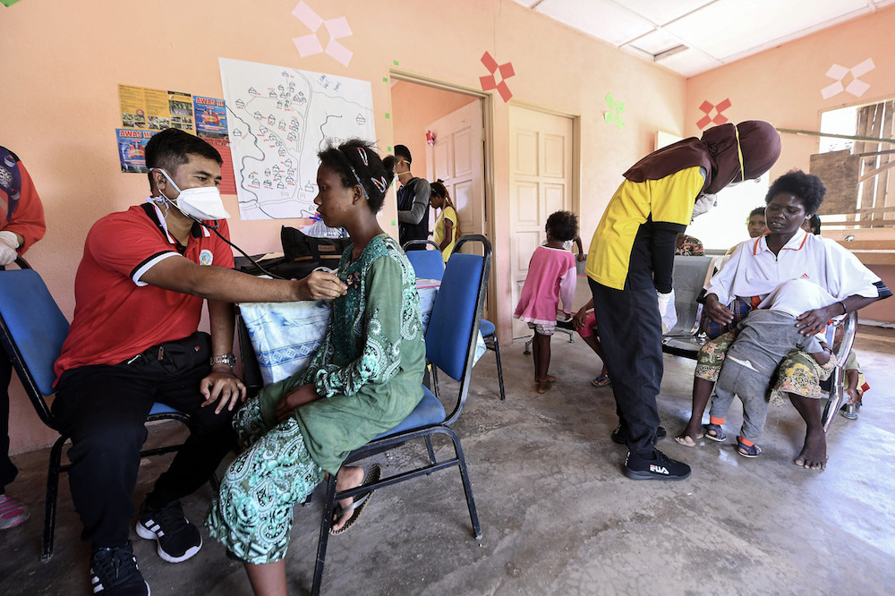 Medical personnel conduct health checks on members of the Batek tribe at the Kuala Koh Orang Asli settlement in Gua Musang June 11, 2019. u00e2u20acu201d Bernama pic