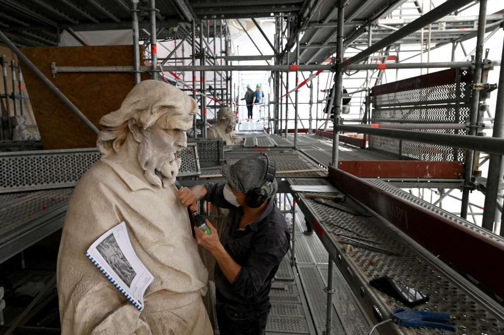 A restorer works on a statue outside the Royal Chapel of Versailles, in the grounds of the Palace of Versailles, southwest of the French capital Paris June 18, 2019. u00e2u20acu201d AFP pic