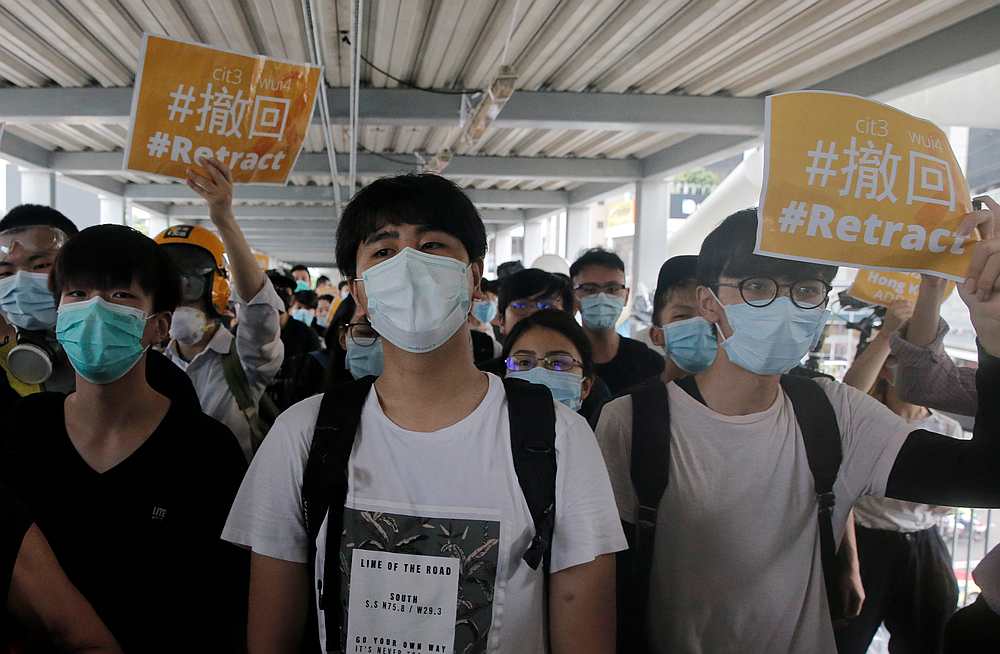 Protesters hold placards and shout slogans on a footbridge leading to the Legislative Council and blocked by police in Hong Kong June 13, 2019. u00e2u20acu201d Reuters pic 