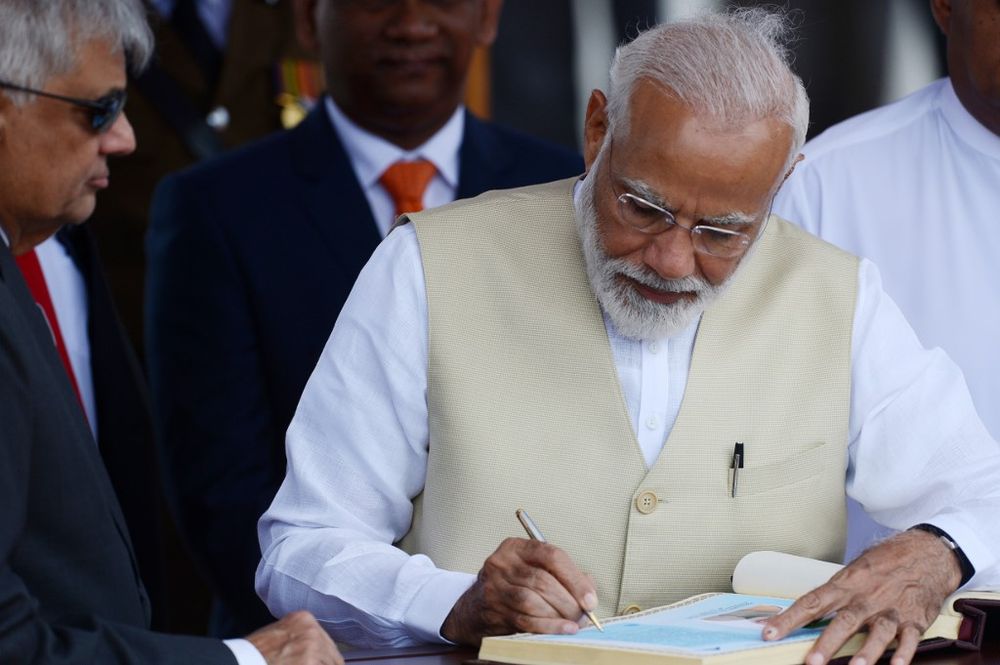 Indian Prime Minister Narendra Modi signs the golden book as Prime Minister of Sri Lanka Ranil Wickremesinghe (left) looks on after his arrival at Bandaranaike International Airport in Katunayake on June 9, 2019. u00e2u20acu201d AFP pic