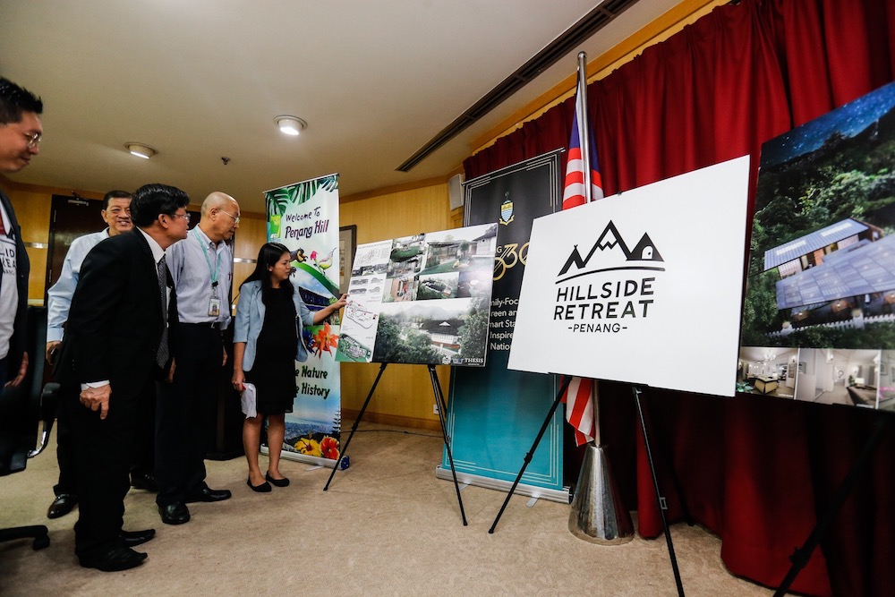 Penang Chief Minister Chow Kon Yeow and Penang Hill Corporation general manager Cheok Lay Leng look at plans for the Penang Hillcrest Retreat in George Town July 12, 2019. u00e2u20acu201d Picture by Sayuti Zainudin