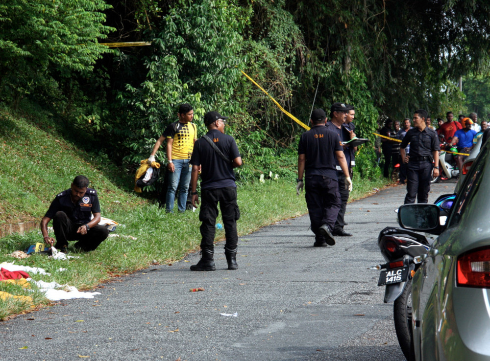 Police officers from the Forensics Unit inspect the scene after a student was found murdered behind a vacant house in Taman Glenview Kamunting near Taiping July 7, 2019. u00e2u20acu201d  Bernama pic
