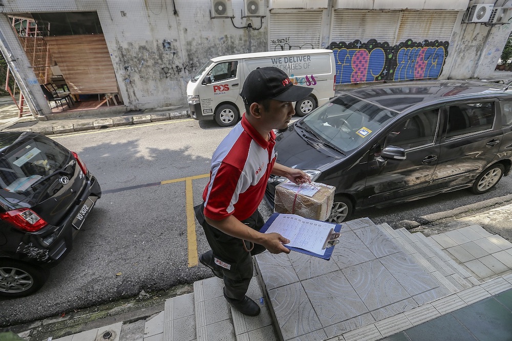 He has to deliver all parcels before 3pm daily. u00e2u20acu201d Picture by Firdaus Latif