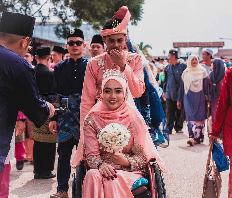 Amirul Syahmi Mohd Yazid with his wheelchair bound wife Siti Aishah Zaid at a marriage solemnisation event. u00e2u20acu201c Picture via Facebook