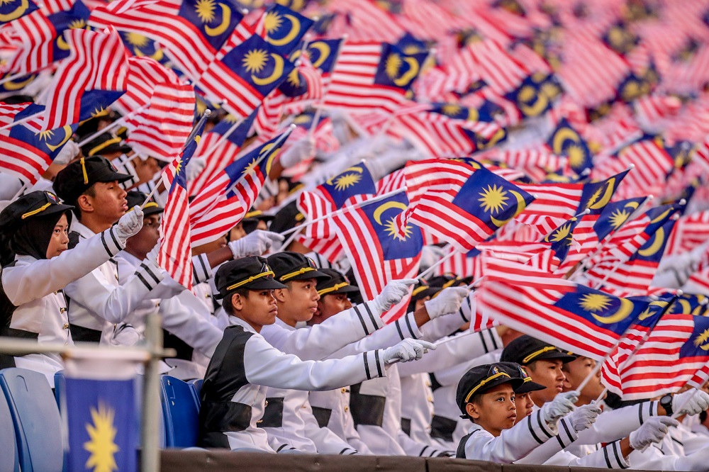 Participant waves the Malaysian flag during the National Day celebrations at Dataran Putrajaya August 31, 2019. u00e2u20acu201d Picture by Firdaus Latif