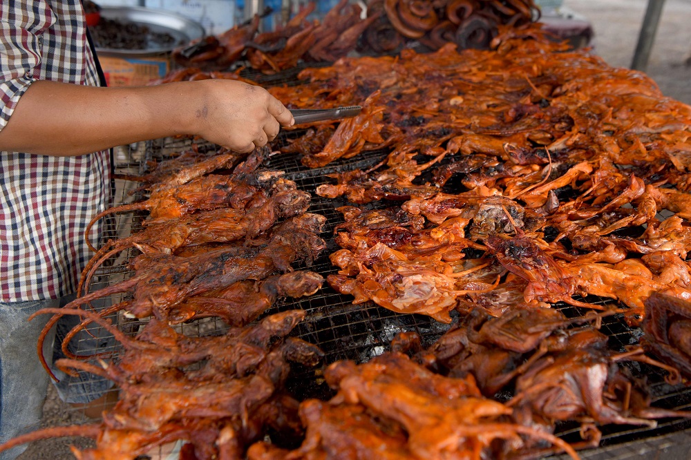 This photo taken on August 10, 2019 shows a man grilling rats at a stall in Battambang province. u00e2u20acu201d AFP pic        