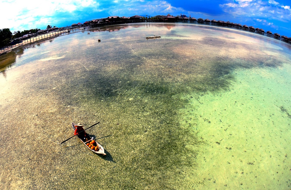 Etnik Bajau menjaja kelapa muda kepada pelancong dengan menggunakan sampan berhampiran pusat peranginan di Pulau Mabul di Semporna 12 Mac, 2019. u00e2u20acu201d Foto Bernama