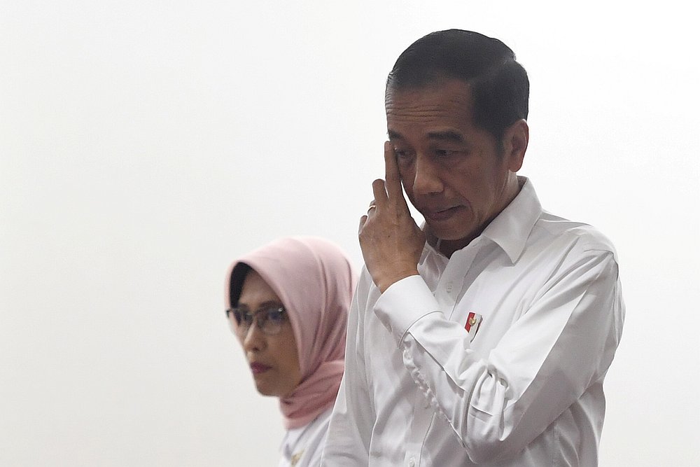 Indonesian President Joko Widodo gestures as he arrives with Sripeni Inten Cahyani, PLN's acting CEO, during a visit to PLN headquarters after a major power blackout in Jakarta August 5, 2019. u00e2u20acu201d Antara Foto/Akbar Nugroho Gumay pic via Reuters