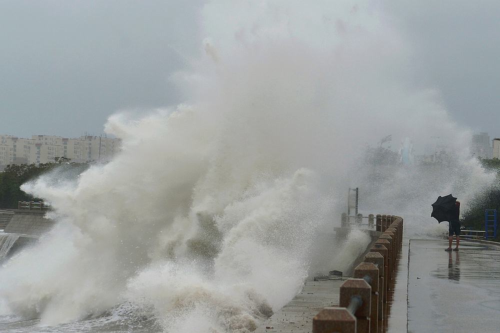 A wave brought by typhoon Lekima breaks on the shore next to a pedestrian in Qingdao, Shandong province, China August 11, 2019. u00e2u20acu201d Reuters pic