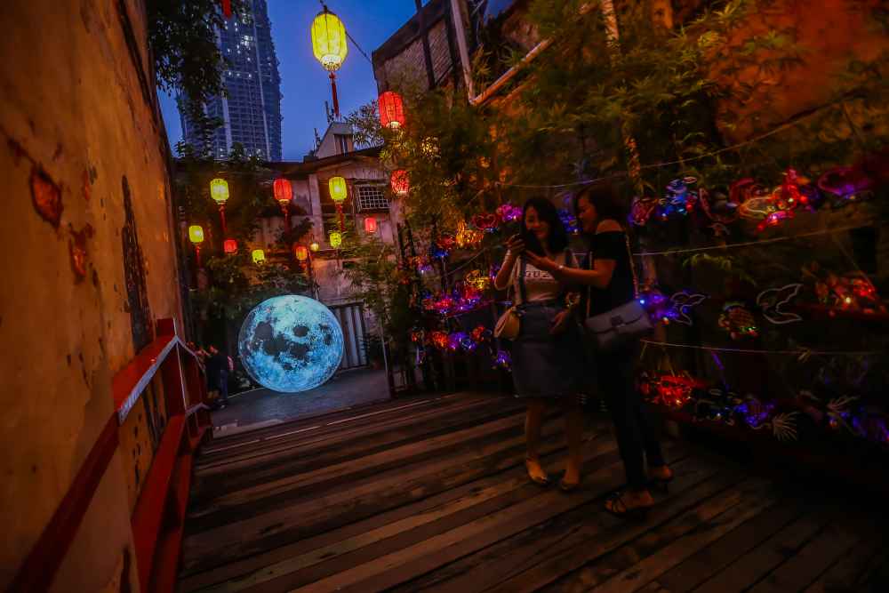 Visitors snap a selfie with traditional hand-painted lanterns at Project Kwai Chai Hong. u00e2u20acu201d Picture by Hari Anggara