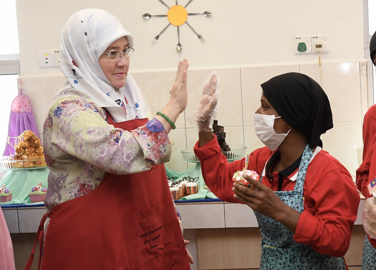 Raja Permaisuri Agong Tunku Azizah Aminah Maimunah Iskandariah high-fives a girl during a visit to Taman Sinar Harapan Ziyad Zolkefli in Cheras September 11, 2019. u00e2u20acu201d Bernama pic