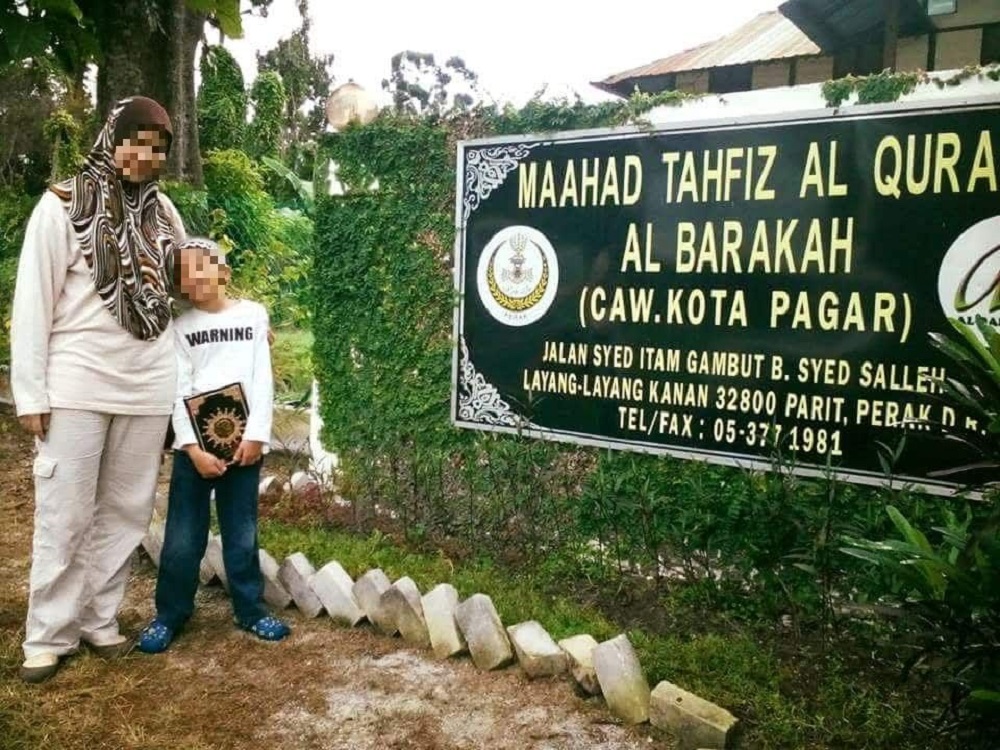 An undated photo of the victim and his mother in front of Maahad Tahfiz al Barakah u00e2u20acu201d the tahfiz school in Manjoi formerly owned by celebrity preacher Datuk Kazim Elias.