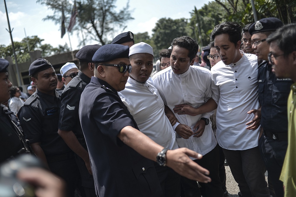 One of the students who took part in the protest in front of Universiti Malaya is led away by police officers in Kuala Lumpur October 25, 2019. — Picture by Shafwan Zaidon