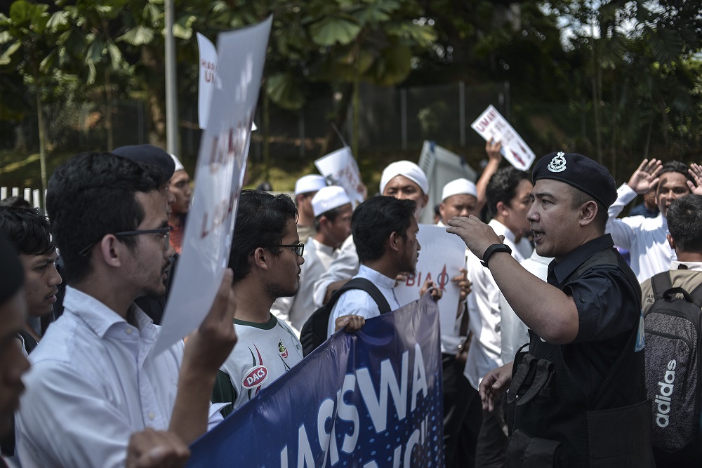 A police officer speaks to the students in front of Universiti Malaya in Kuala Lumpur October 25, 2019. u00e2u20acu201d Picture by Shafwan Zaidon