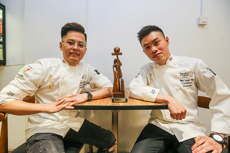 Loi Ming Ai (left) with Tan Wei Loon (right) from the winning team at the World Pastry Cup pose with their trophy at Xiao by Crustz. – File picture by Hari Anggara 