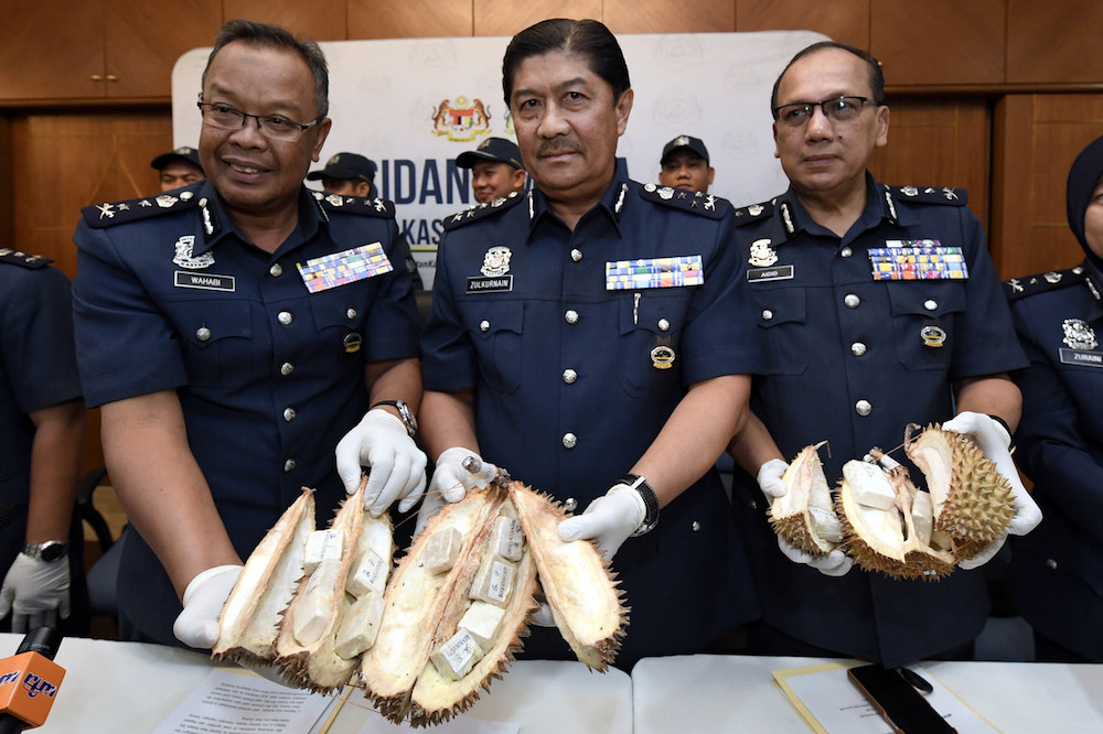 Central Zone Customs assistant director-general Datuk Zulkarnain Mohamed Yusuf (centre) holds samples of the heroin-packed durians during a press conference in Petaling Jaya October 18, 2019. u00e2u20acu201d Bernama pic