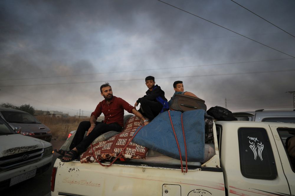 People sit on belongings at a back of a truck as they flee Ras al Ain town, Syria October 9, 2019. u00e2u20acu2022 Reuters pic