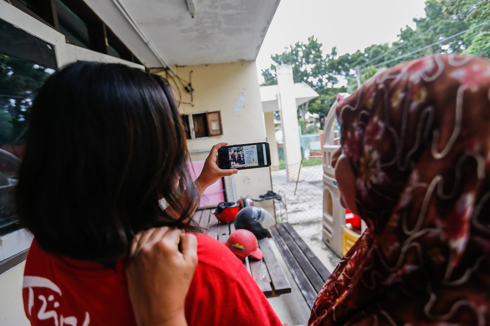 Noor Wahida Baba Din and her daughter Nur Dhamirah Lee watch the Budget 2020 speech by Finance Minister Lim Guan Eng u00e2u20acu02dcliveu00e2u20acu2122 on the phone at home in Bukit Gelugor October 11, 2019. u00e2u20acu201d Picture by Sayuti Zainudin