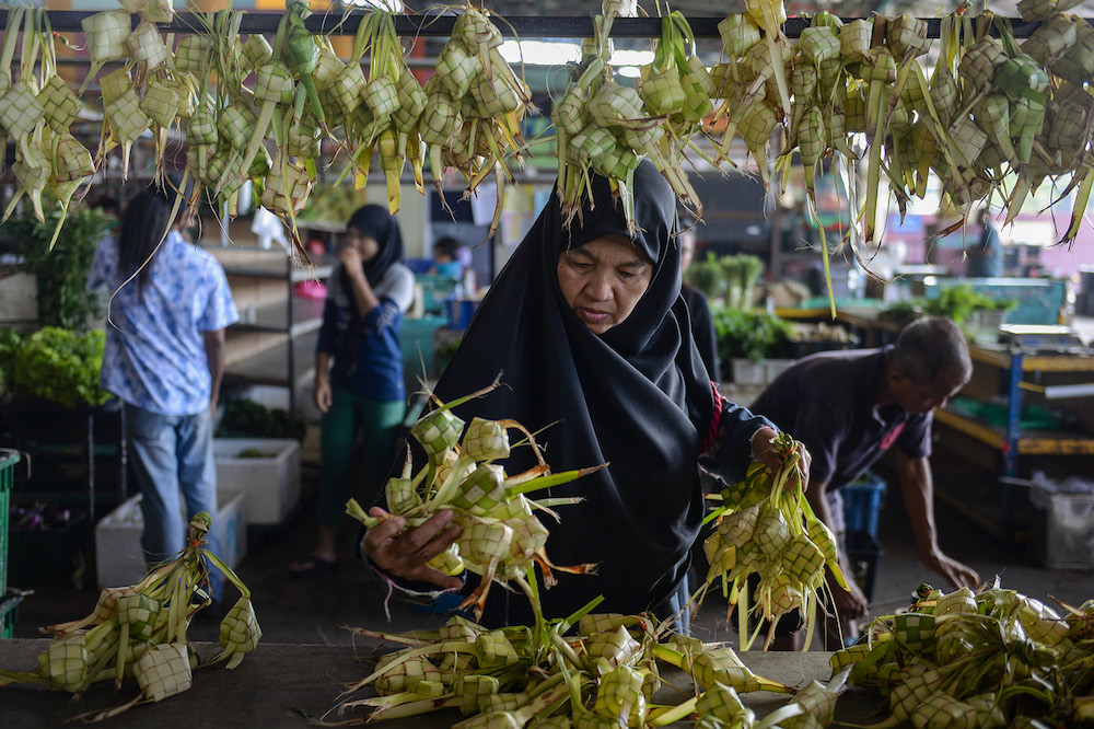 A woman buys ingredients for ketupat and rendang in Kuala Lumpur ahead of Hari Raya Aidilfitri celebrations. u00e2u20acu201d Picture by Mukhriz Hazim.
