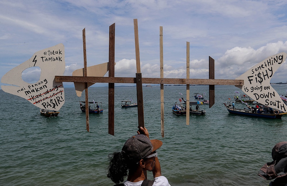 A man holds a signboard in protest against the proposed Penang South Reclamation project at the Esplanade November 4, 2019. — Picture by Sayuti Zainudin