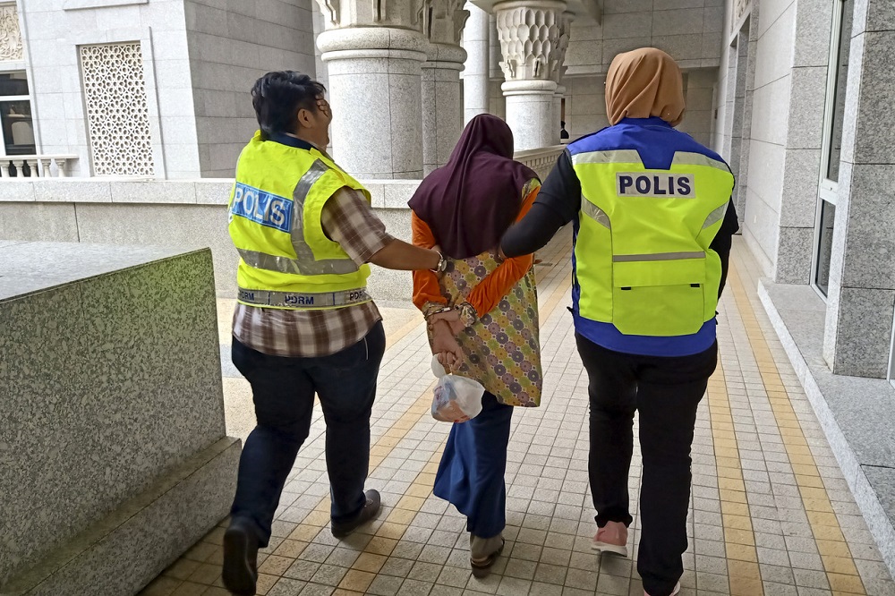 Police personnel lead one of the accused out of the Magistrate Court in Putrajaya November 15, 2019. u00e2u20acu201d Bernama pic