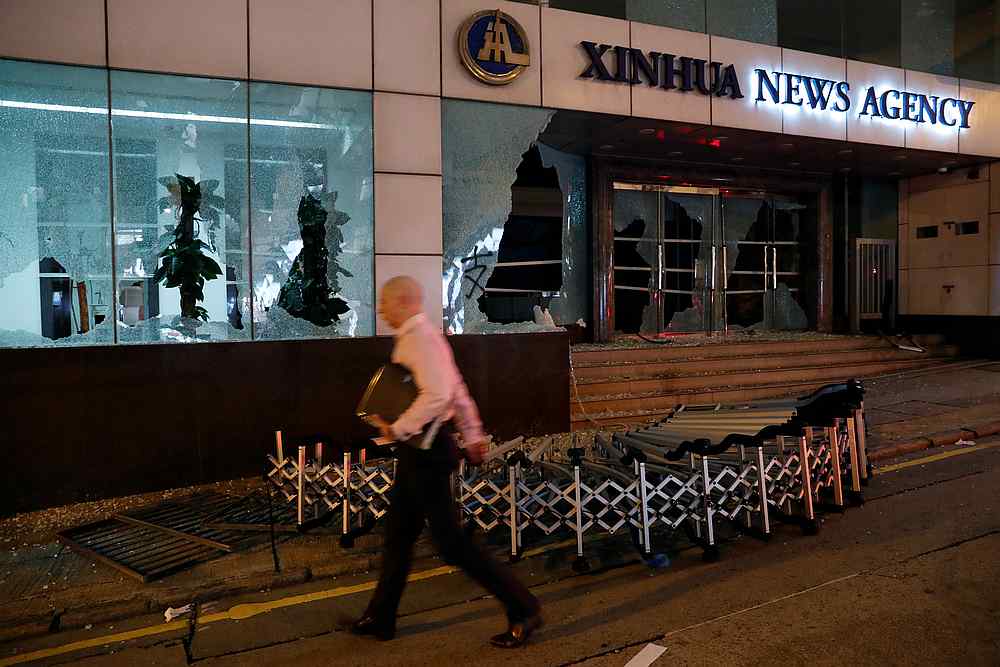 A man walks past a damaged entrance of China's official Xinhua news agency during anti-government protest in Hong Kong November 2, 2019. u00e2u20acu201d Reuters pic
