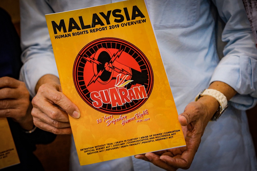 Suaram adviser Kua Kia Soong holds a copy of the Suaram Human Rights Report 2019 during its launch in Kuala Lumpur December 9, 2019. — Picture by Hari Anggara