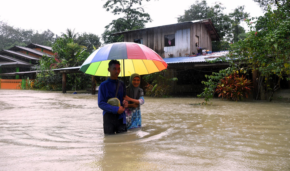 A mother and son are evacuated from their flooded home in Besut December 3, 2019. u00e2u20acu201d Bernama pic