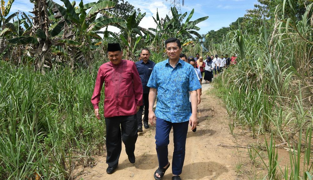 PKR deputy president and Minister of Economic Affairs Datuk Seri Mohamed Azmin Ali, accompanied by Assemblyman Datuk Mohd Arifin Arif (left) walking to a get-together with locals in Kampung Baitam Baru, Kimanis, Sabah, January 17, 2020. u00e2u20acu201d Bernama pic