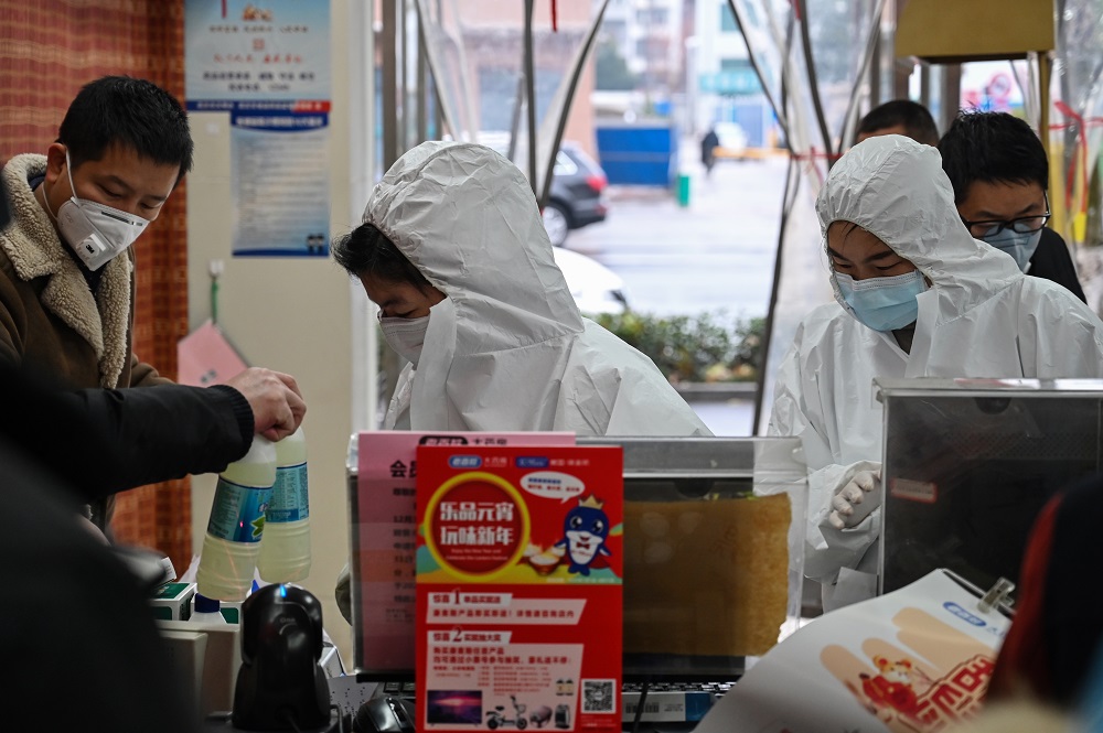 Pharmacy workers wearing protective clothes and masks serve customers in Wuhan January 25, 2020. u00e2u20acu201d AFP pic