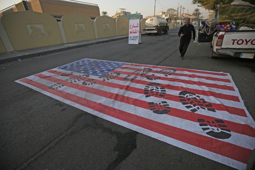 A mock US flag is laid on the ground for cars to drive on in the Iraqi capital Baghdad, January 3, 2020, following news of the killing of Iranian Revolutionary Guards top commander Qassem Soleimani in a US strike on his convoy at Baghdad airport. u00e2u20acu201d AFP 